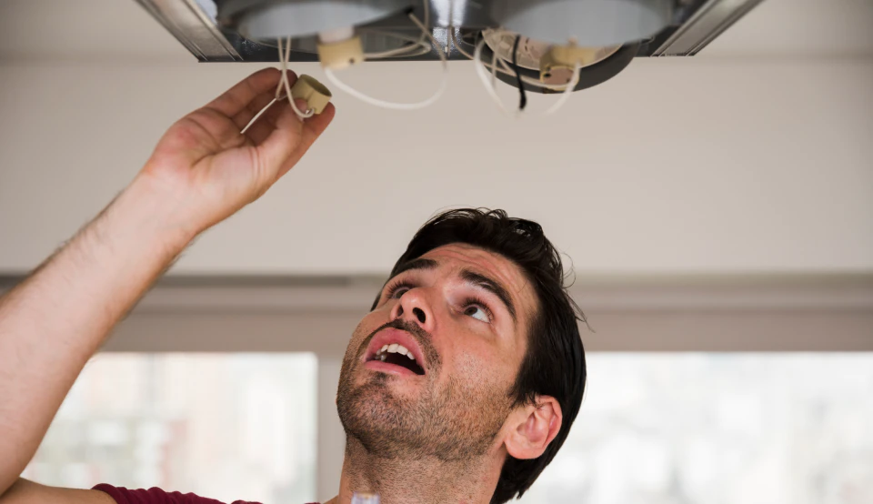 close up male electrician installing holder ceiling light