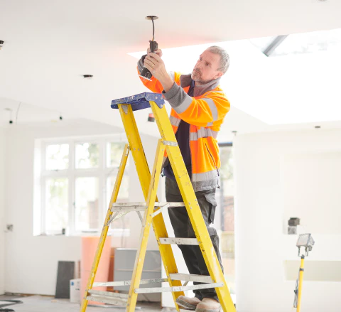 electrician installing downlights